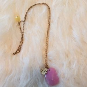 Gold chain necklace with pink pendant.